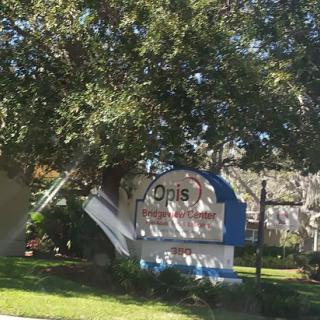 A sign indicating the presence of a residential community named 'Opus' surrounded by greenery.