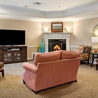A cozy living room with a sofa facing a fireplace and a television.