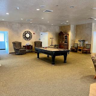 A spacious game room featuring a pool table and comfortable seating.