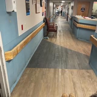 A view of a hospital corridor featuring a waiting area and medical environment.