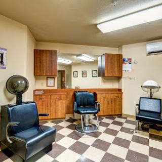 A cozy barbershop interior featuring classic chairs and a checkered floor.