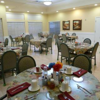 An indoor dining room with several tables set for a meal.