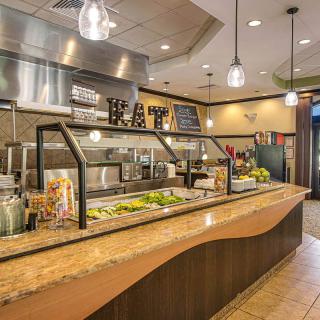 A modern restaurant interior featuring a buffet-style salad bar with various fresh ingredients.