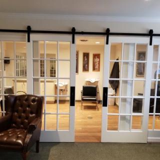 A cozy office interior with glass sliding doors and a leather armchair.