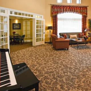A spacious living room featuring a piano, comfortable seating, and stylish decor.