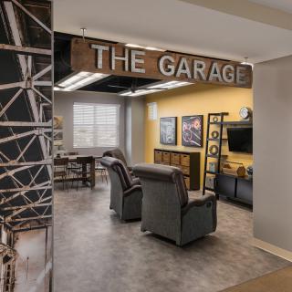 A cozy lounge area labeled 'The Garage' with comfortable seating and a TV.