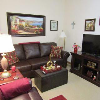 A cozy living room with a leather sofa, decorative pillows, and a television.