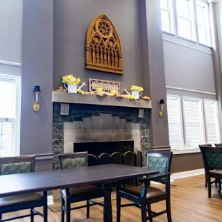 A dining area featuring a central fireplace with decorative elements and ample natural light.