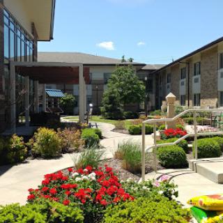 A beautifully landscaped courtyard featuring vibrant flowers and a winding pathway.