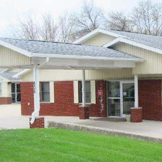 A modern single-story building featuring a combination of brick and siding with a landscaped front yard.