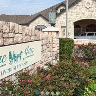 Entrance of a retirement home with landscaped garden and signage.
