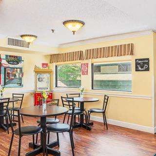 A cozy cafe interior with several tables and chairs, featuring casual decor.