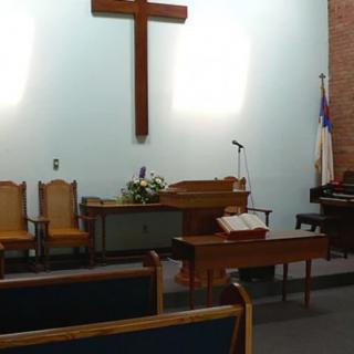 Interior of a church with a cross and pulpit.