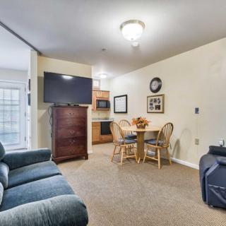 A cozy living space with a sofa, dining area, and kitchen in view.
