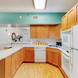 A spacious and modern kitchen featuring wooden cabinetry and white appliances, designed for functionality and style.