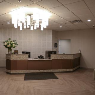 A modern office reception area with a central desk and decorative lighting.