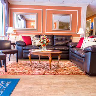 A cozy living room with comfortable sofas, a wooden coffee table, and decorative cushions.