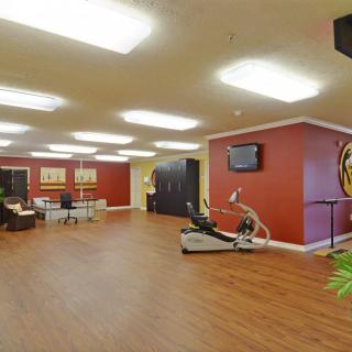 A modern, spacious gym interior with exercise equipment and wooden floors.