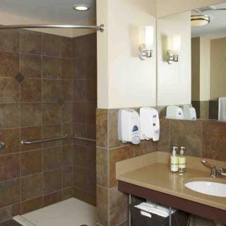 A modern bathroom with a walk-in shower, a sink with a mirror, and elegant tile walls.