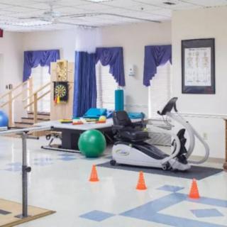 Rehabilitation room with exercise equipment and therapy tools.