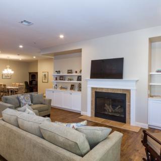 A modern living room with an open concept layout, featuring a fireplace, built-in shelves, and a comfortable seating area.