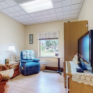 A cozy living space with comfortable seating, a television, and natural light from a window.