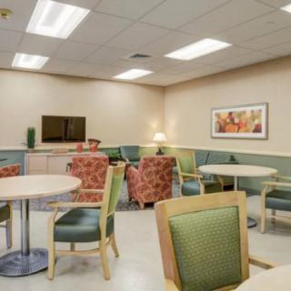 A well-lit waiting room with comfortable seating and tables.