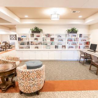 A cozy lounge area with comfortable seating and bookshelves, featuring a computer desk for added convenience.