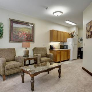 A cozy living room with comfortable seating and a small kitchenette.