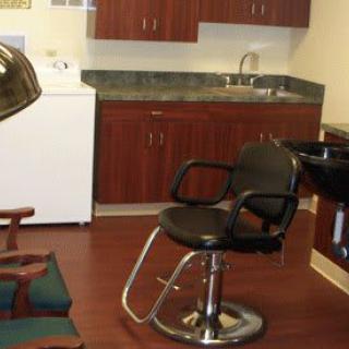 A hair salon interior with a barber chair and styling equipment.