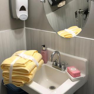 A neatly arranged bathroom setup with yellow towels, soap, and a mirror.