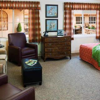 A cozy bedroom with comfortable seating and warm decor.