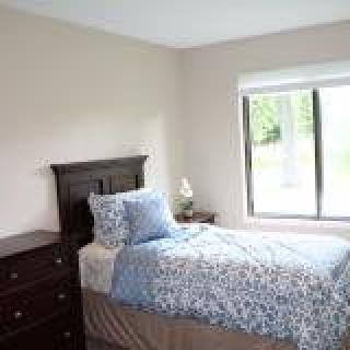 A tidy bedroom with a single bed and a window allowing natural light.
