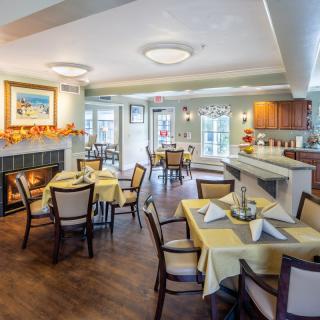 A cozy dining area with neatly arranged tables and a fireplace, creating a warm and inviting atmosphere.