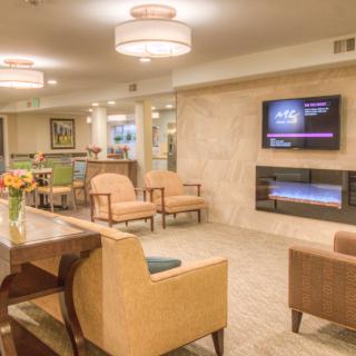 A modern lobby with comfortable seating, ambient lighting, and a television on the wall.