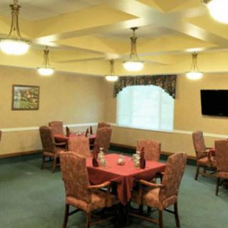 A well-lit dining room with neatly arranged tables and chairs.
