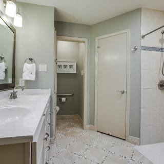 A modern bathroom with a double-sink vanity, mirror, and tiled floor.