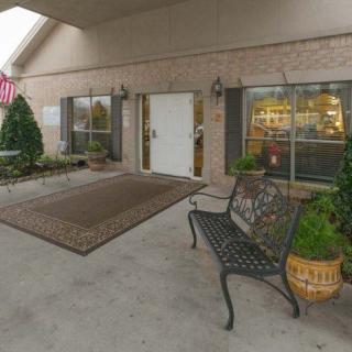 An inviting entrance with a bench and decorative plants outside a building.