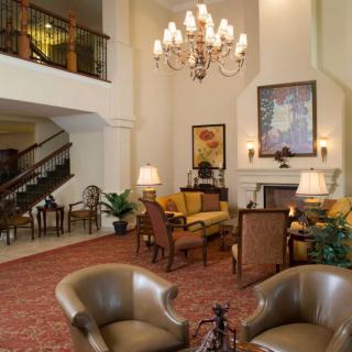 A cozy hotel lobby with elegant seating and a grand chandelier.