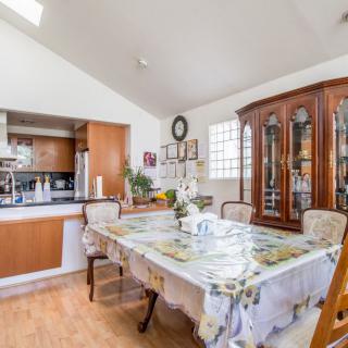A cozy dining room with a well-set table and adjoining kitchen.