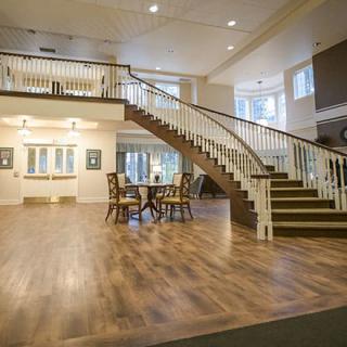 A spacious interior with a grand staircase and wooden flooring.