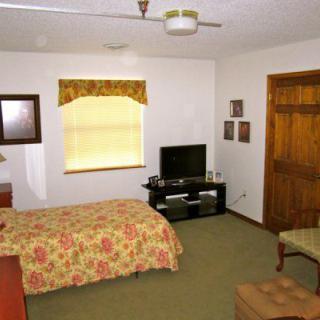 A cozy bedroom with a bed, television, and window.