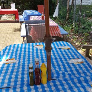 A vibrant outdoor dining setup featuring checkered tables and condiments for guests.