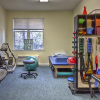 A physical therapy room equipped with various exercise and rehabilitation equipment.