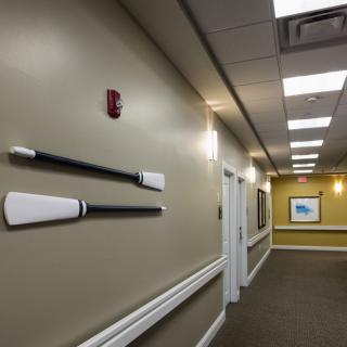 A hallway with decorative oars mounted on the wall and framed artwork.