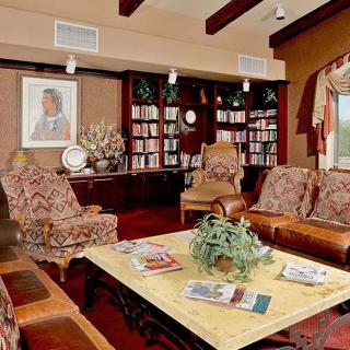 A cozy living room with elegant seating and bookshelves.