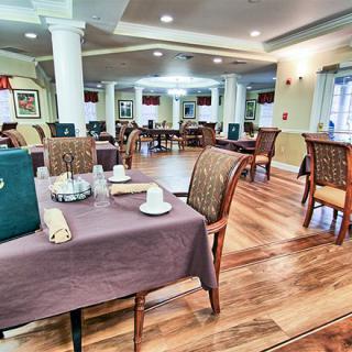A spacious dining room with neatly arranged tables and chairs, featuring a warm interior decor.
