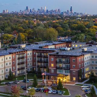 Aerial view of an apartment complex with a city skyline in the background.
