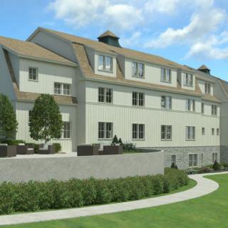 A modern residential building with landscaped surroundings and a clear sky.