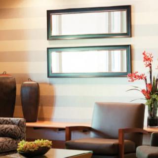 A modern living room interior featuring mirrors, vases, and comfortable seating.